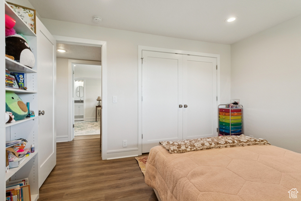 Bedroom featuring wood finished floors, recessed lighting, and a closet