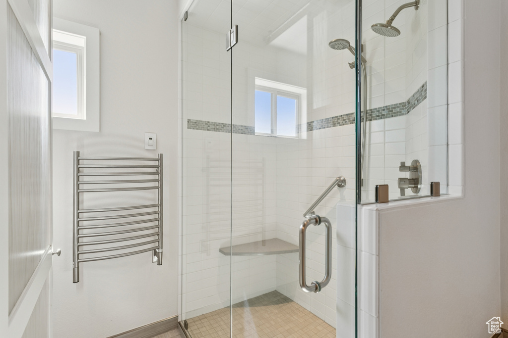 Bathroom with radiator, a stall shower, and a towel warmer