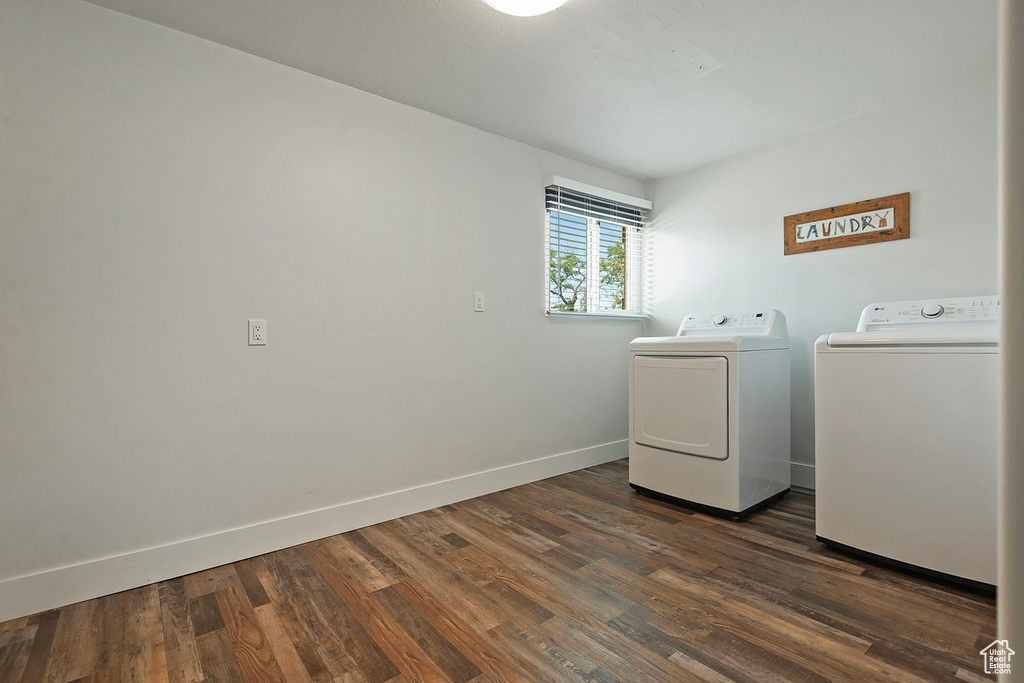 Laundry room featuring washing machine and dryer and dark wood-type flooring
