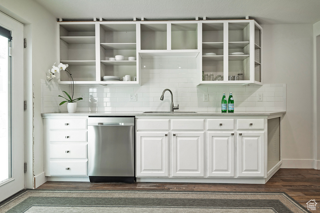 Indoor wet bar featuring stainless steel dishwasher, dark wood finished floors, and backsplash