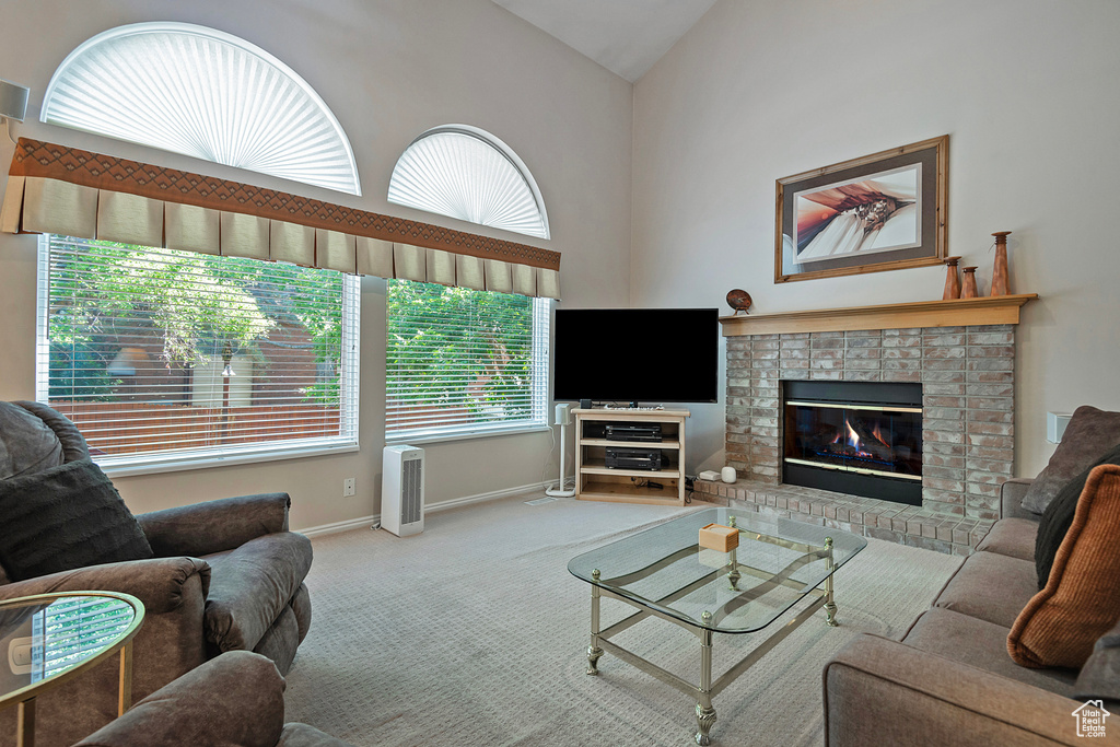 Living area featuring carpet floors, a fireplace, and high vaulted ceiling
