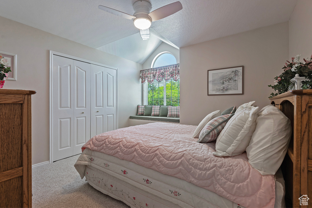 Bedroom with carpet flooring, lofted ceiling, a closet, and a ceiling fan