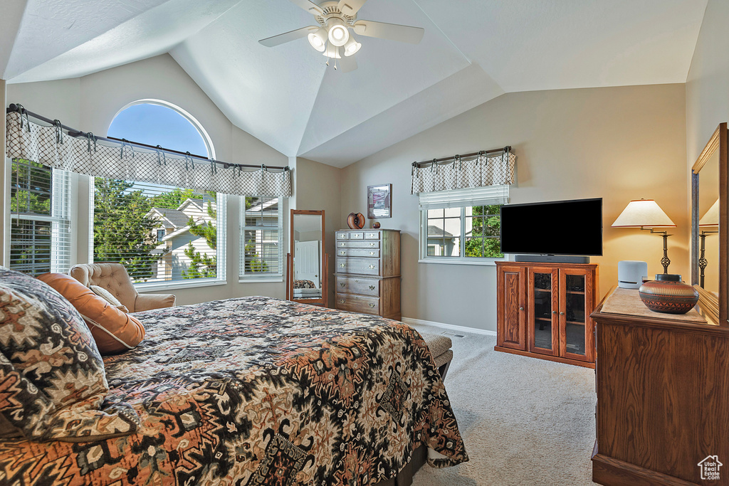 Bedroom with carpet, lofted ceiling, multiple windows, and ceiling fan