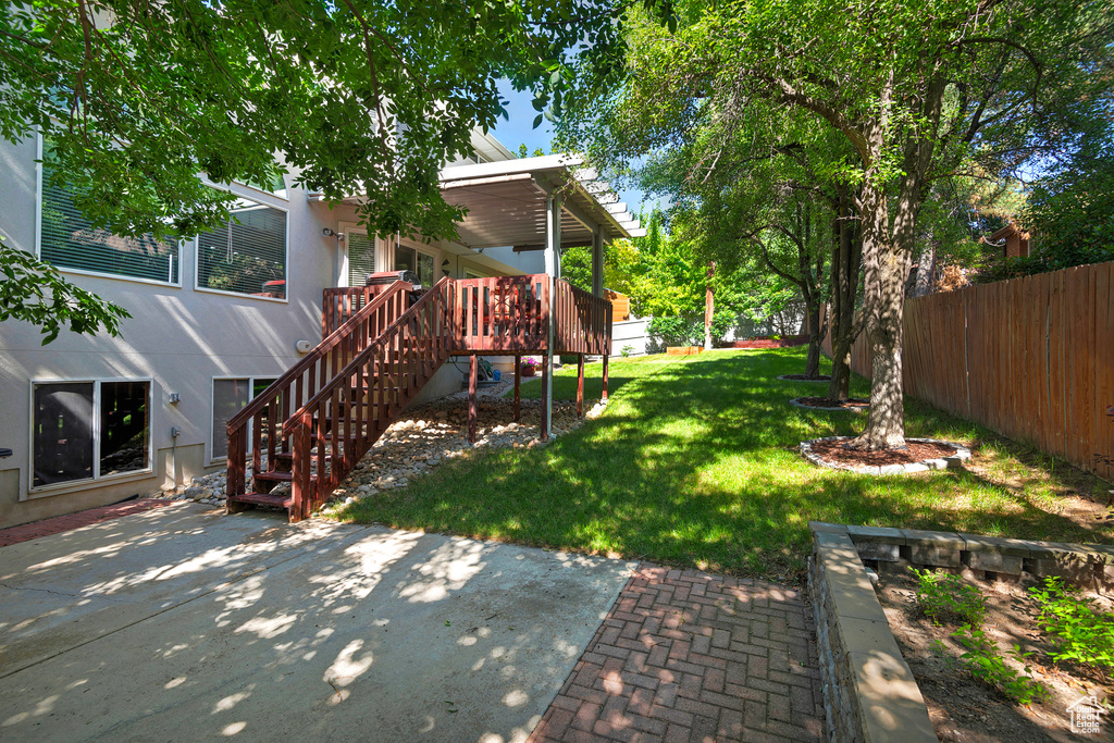View of yard featuring a patio, a wooden deck, and stairway