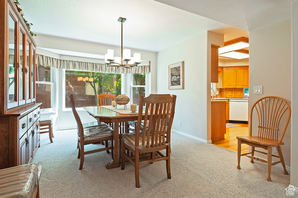 Dining room with light carpet and a chandelier