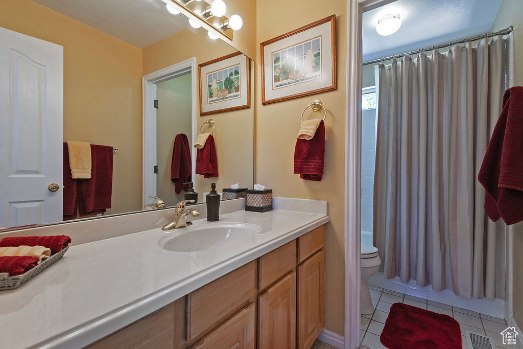 Bathroom featuring vanity, tile patterned flooring, and shower / tub combo