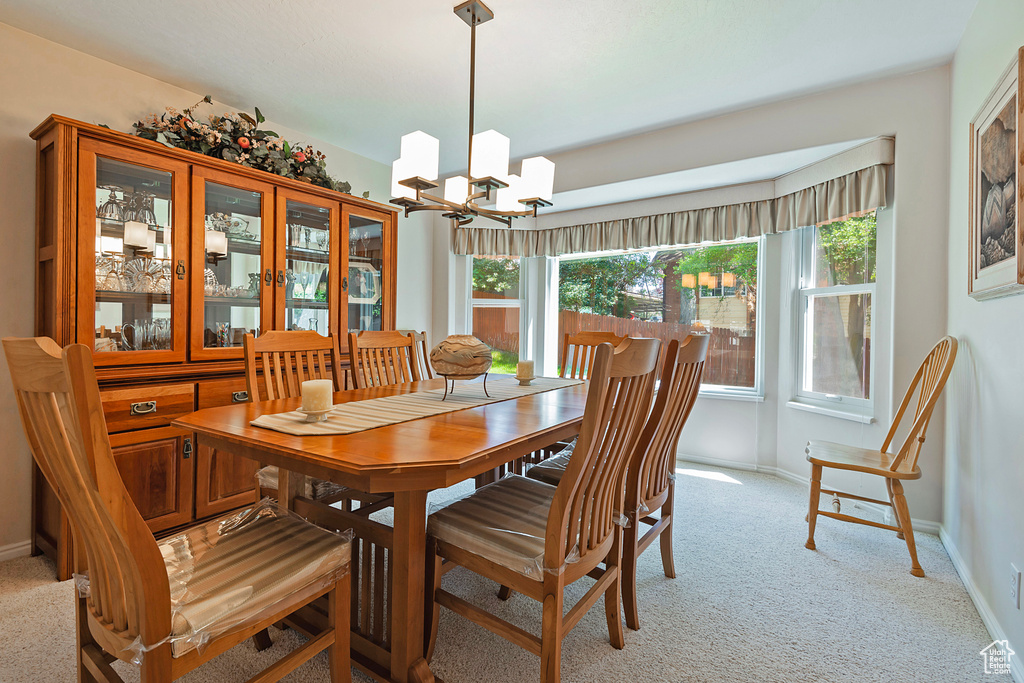 Dining room featuring light colored carpet and a chandelier