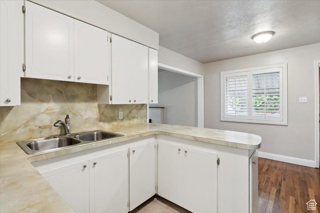 Kitchen featuring light countertops, decorative backsplash, and white cabinetry