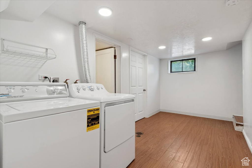 Laundry area featuring washer and dryer, light wood-type flooring, and recessed lighting