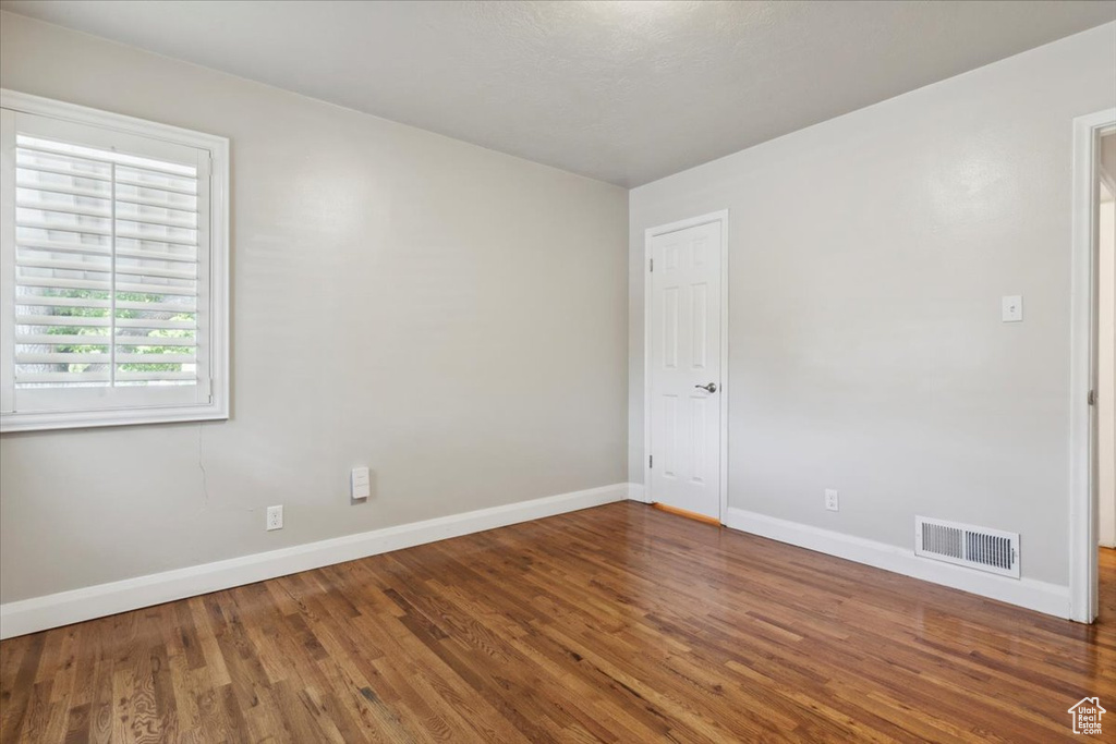 Spare room featuring wood finished floors and baseboards