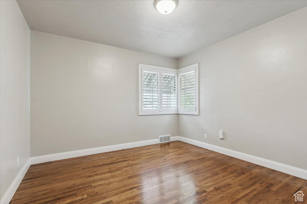Spare room featuring wood finished floors and baseboards