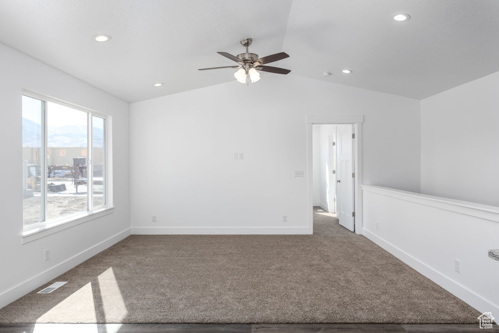 Carpeted empty room with lofted ceiling, ceiling fan, and recessed lighting