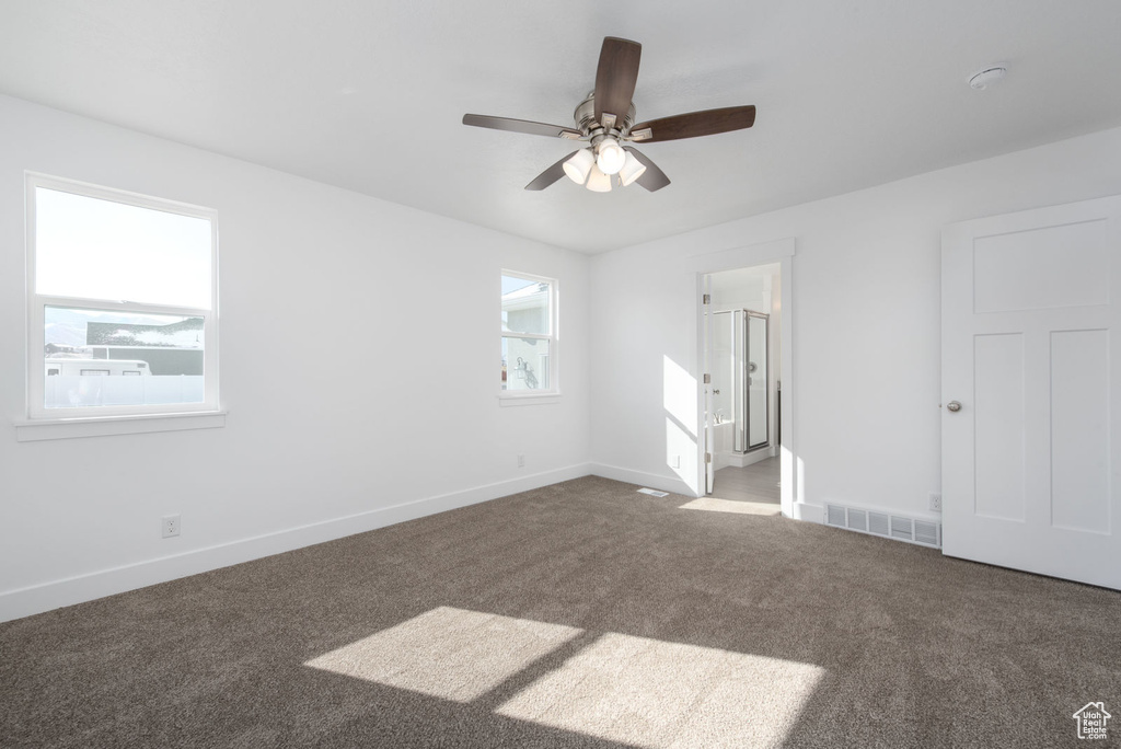 Unfurnished bedroom with carpet flooring, connected bathroom, and a ceiling fan