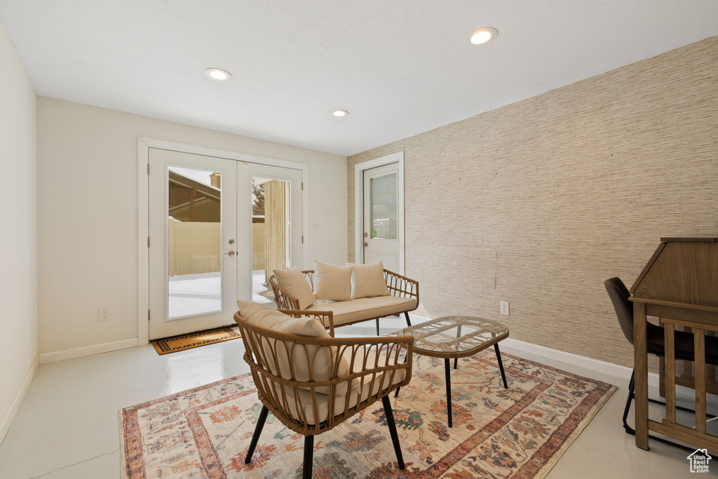 Living area featuring french doors, recessed lighting, and finished concrete flooring