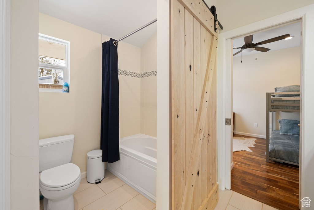 Bathroom featuring shower / bath combo with shower curtain, a ceiling fan, and wood finished floors