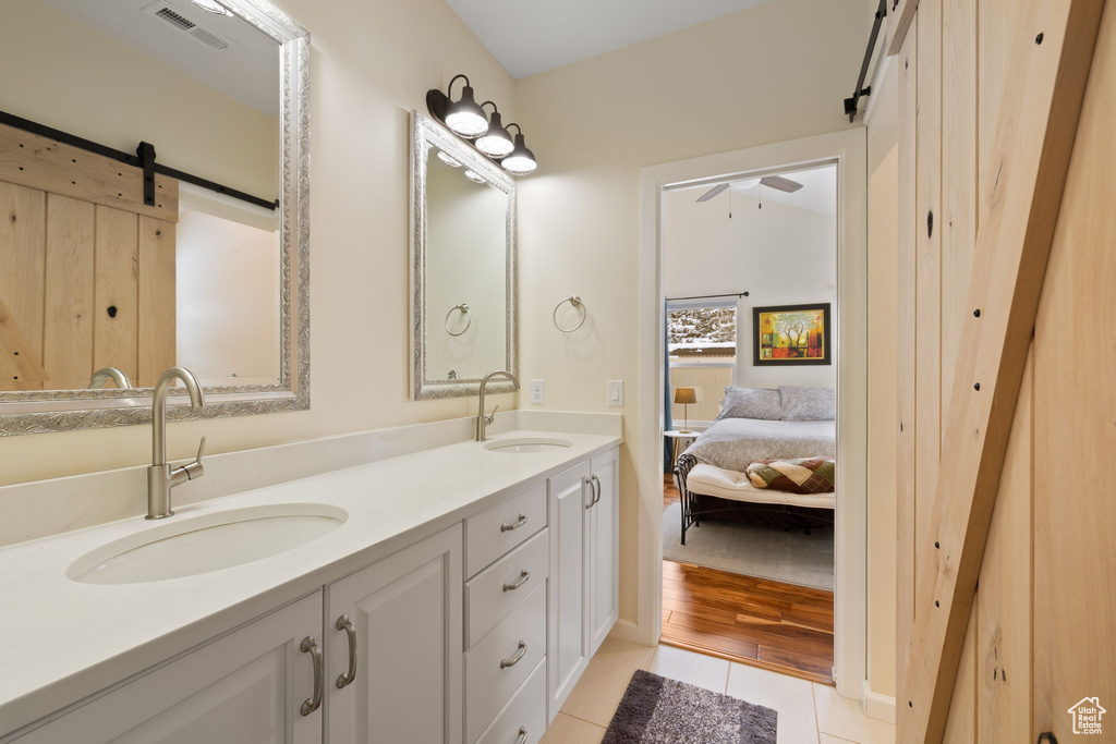 Full bathroom featuring tile patterned floors, double vanity, a ceiling fan, and ensuite bathroom