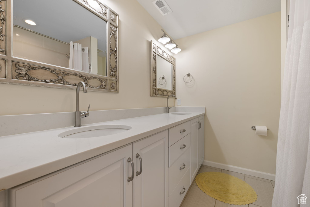 Bathroom featuring double vanity and tile patterned floors
