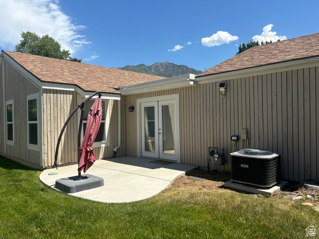 Back of house featuring french doors, a yard, a mountain view, and a patio