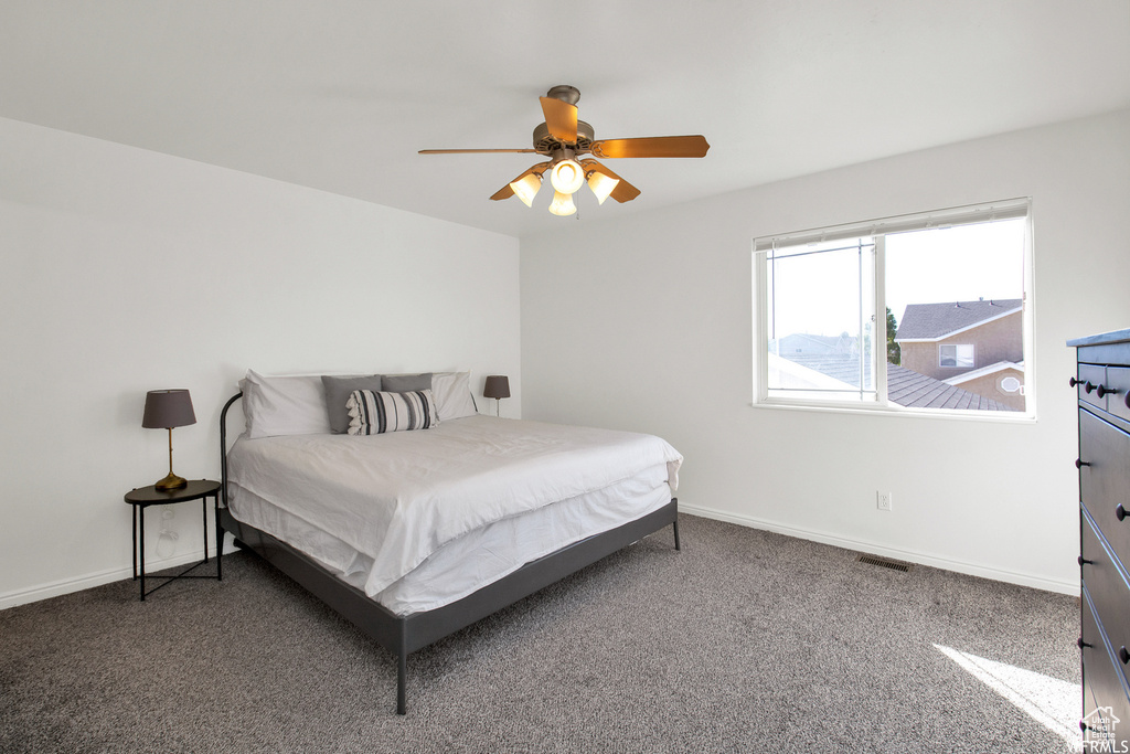 Carpeted bedroom with baseboards and ceiling fan