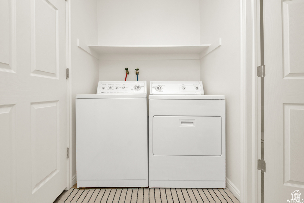 Washroom featuring independent washer and dryer and baseboards