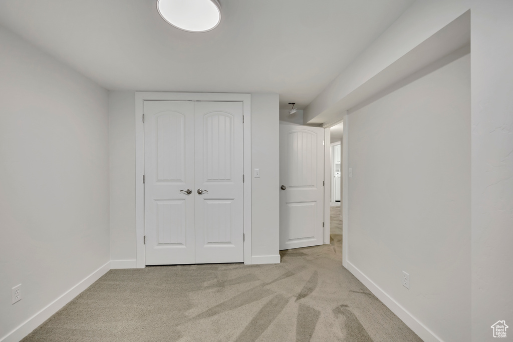 Unfurnished bedroom featuring light colored carpet and a closet