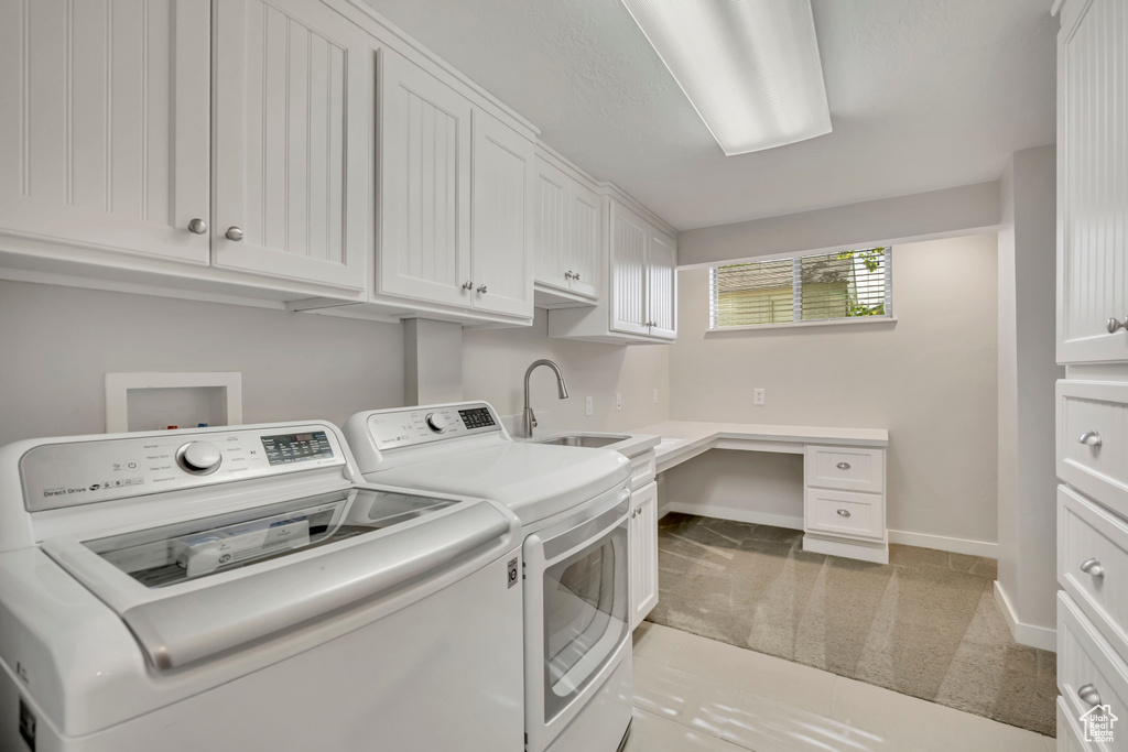 Washroom with washing machine and dryer, light carpet, and cabinet space