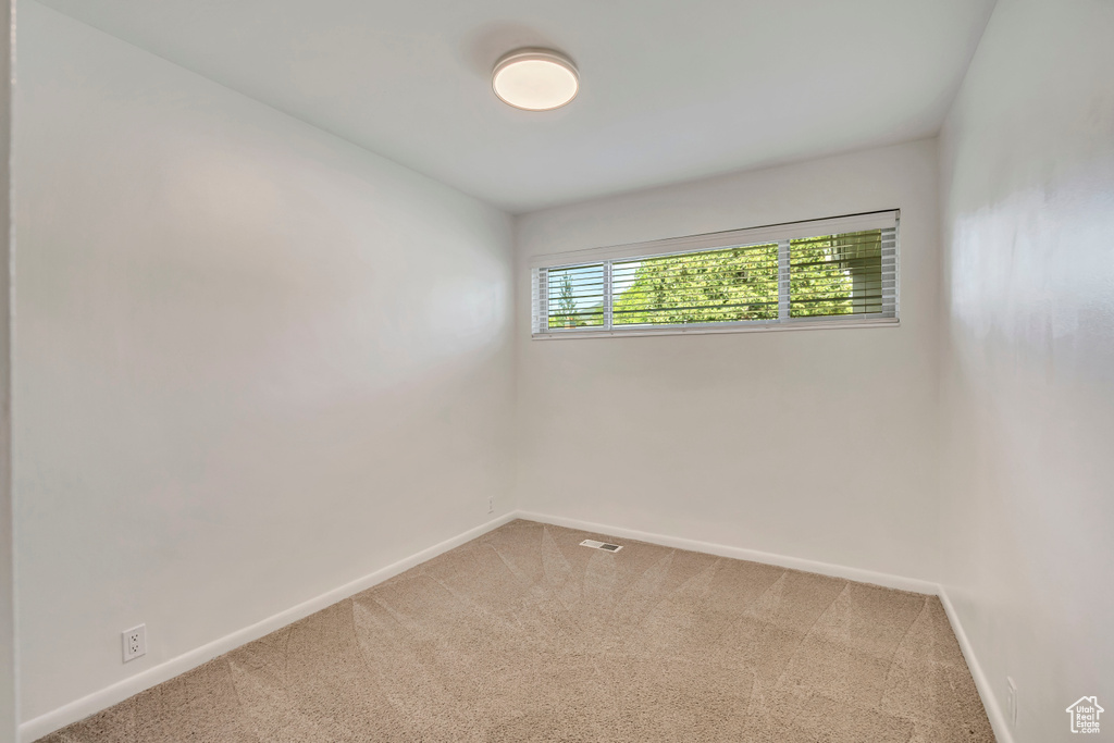 Empty room with carpet and baseboards