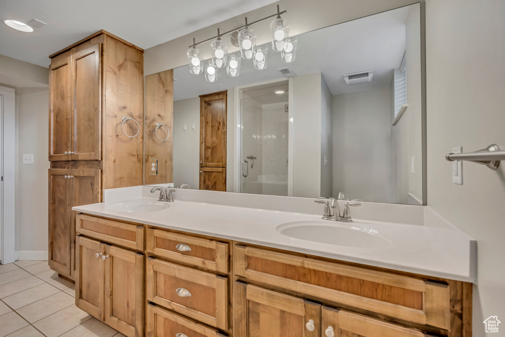 Full bathroom featuring tile patterned flooring, double vanity, and a shower stall
