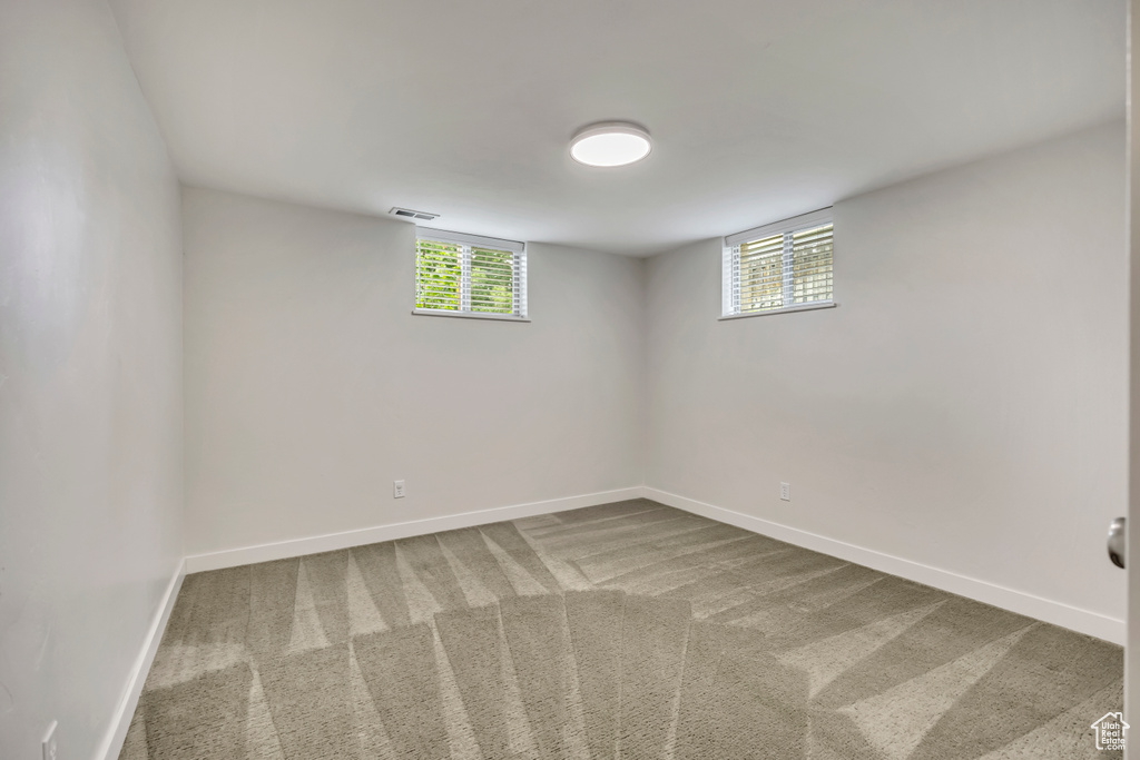 Below grade area featuring plenty of natural light and carpet flooring