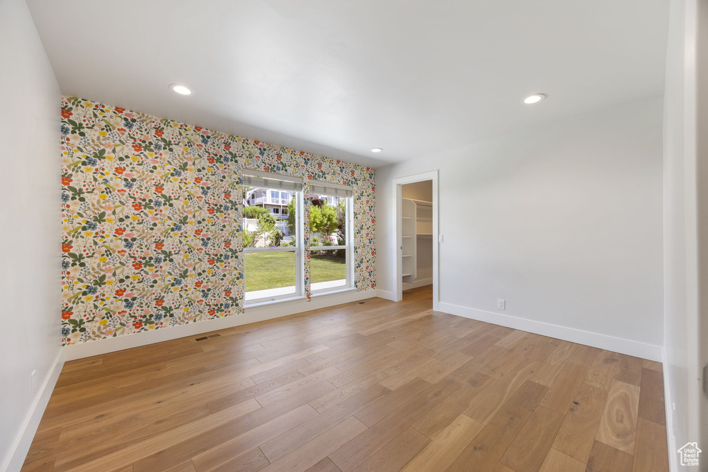 Spare room with wallpapered walls, light wood-style flooring, and recessed lighting