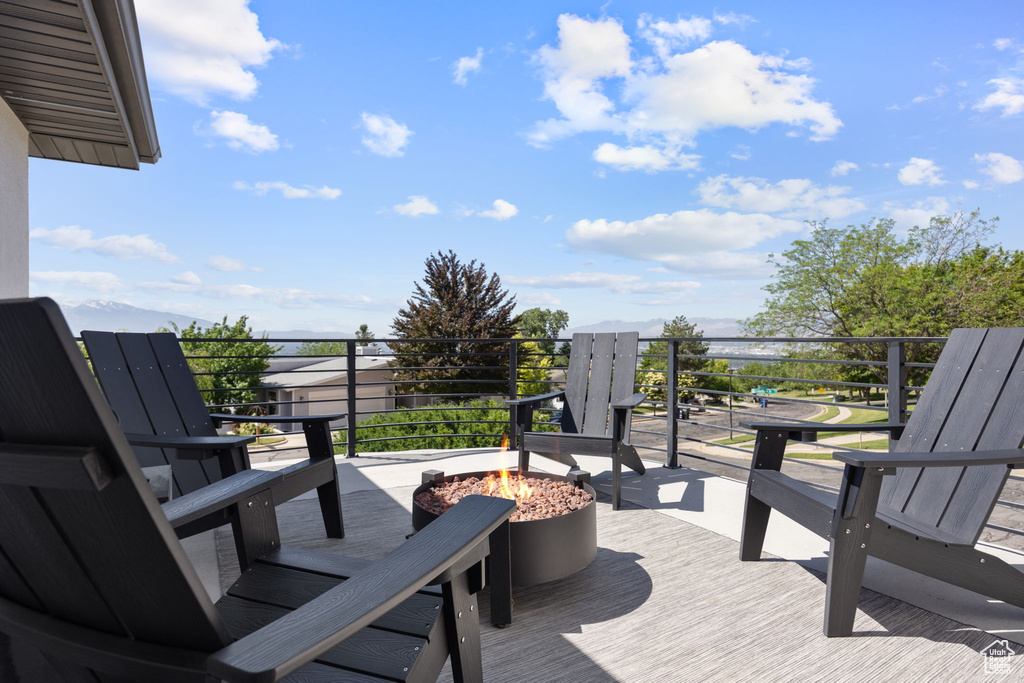 Wooden deck with an outdoor fire pit and a mountain view