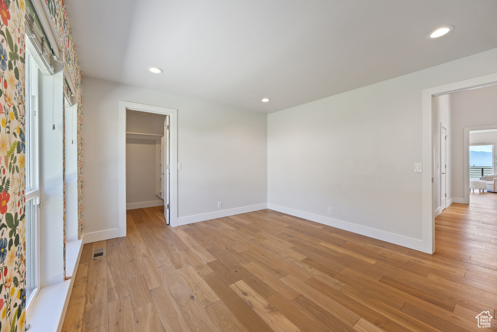 Unfurnished bedroom with light wood-type flooring, recessed lighting, and a walk in closet