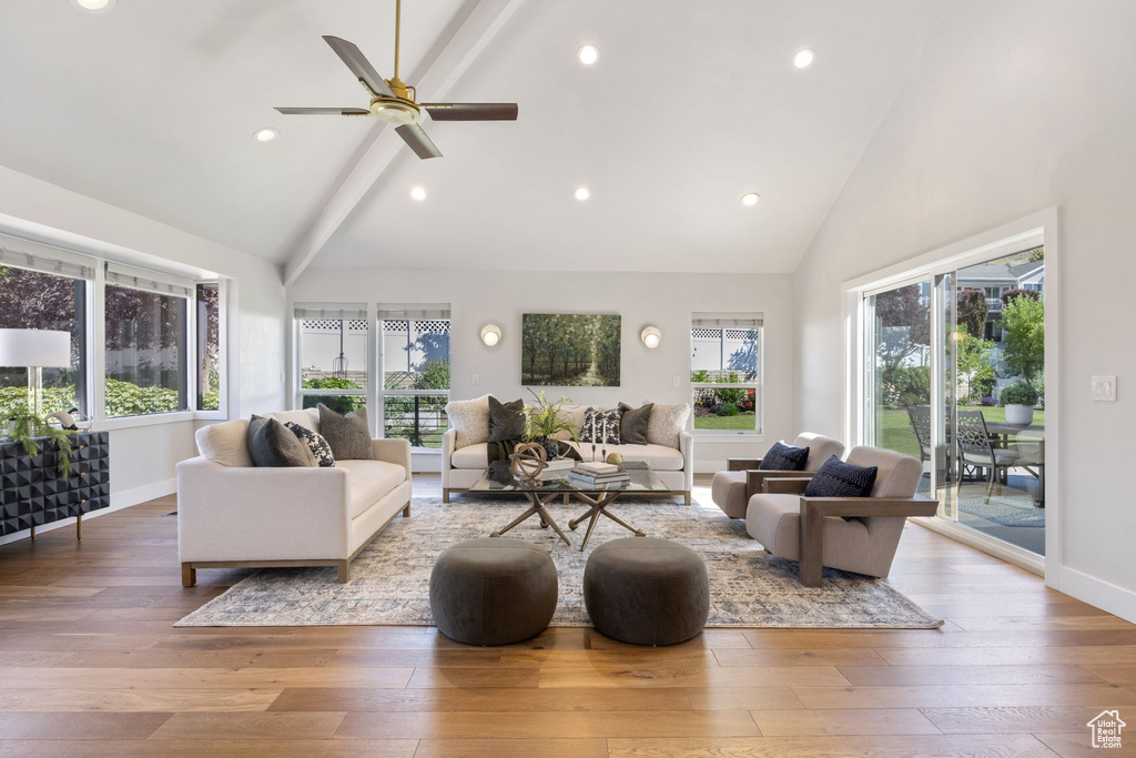 Living room featuring high vaulted ceiling, beam ceiling, plenty of natural light, wood-type flooring, and recessed lighting