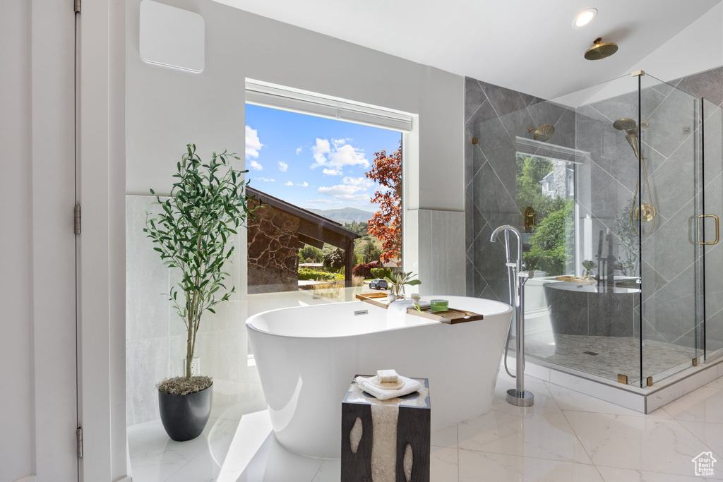 Bathroom with a stall shower, a freestanding bath, marble finish flooring, and recessed lighting