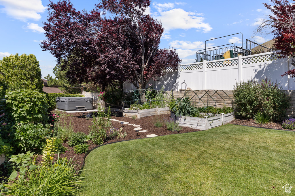 View of yard with a vegetable garden and a hot tub