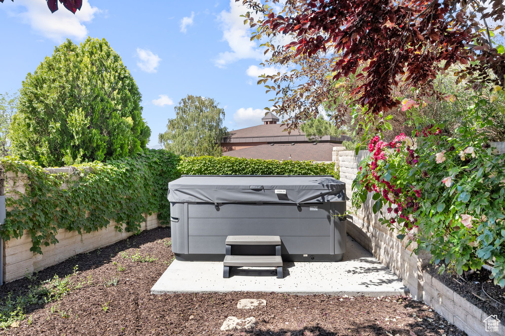 Fenced backyard featuring a hot tub and a patio area