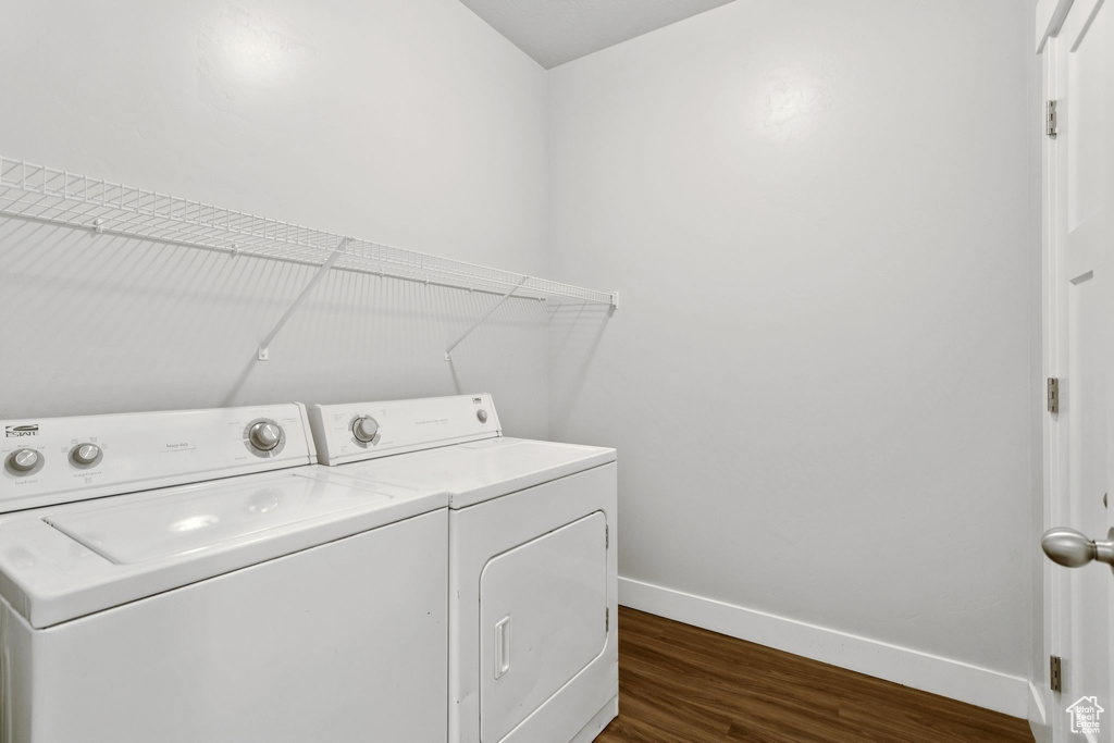 Washroom featuring dark wood-type flooring and washing machine and dryer