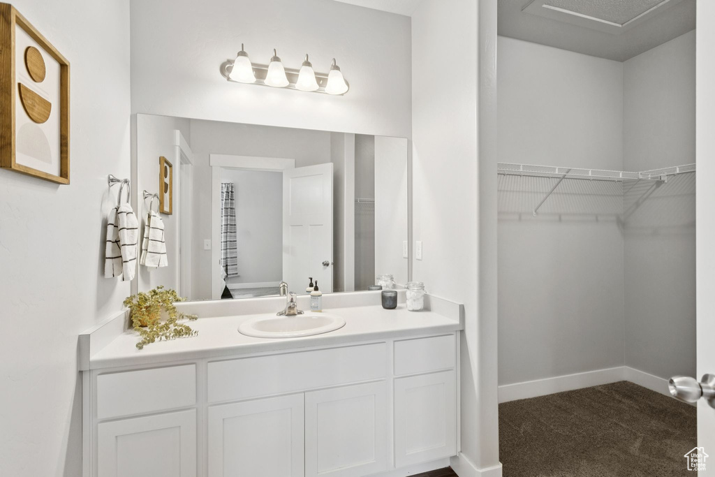 Bathroom featuring vanity and a spacious closet