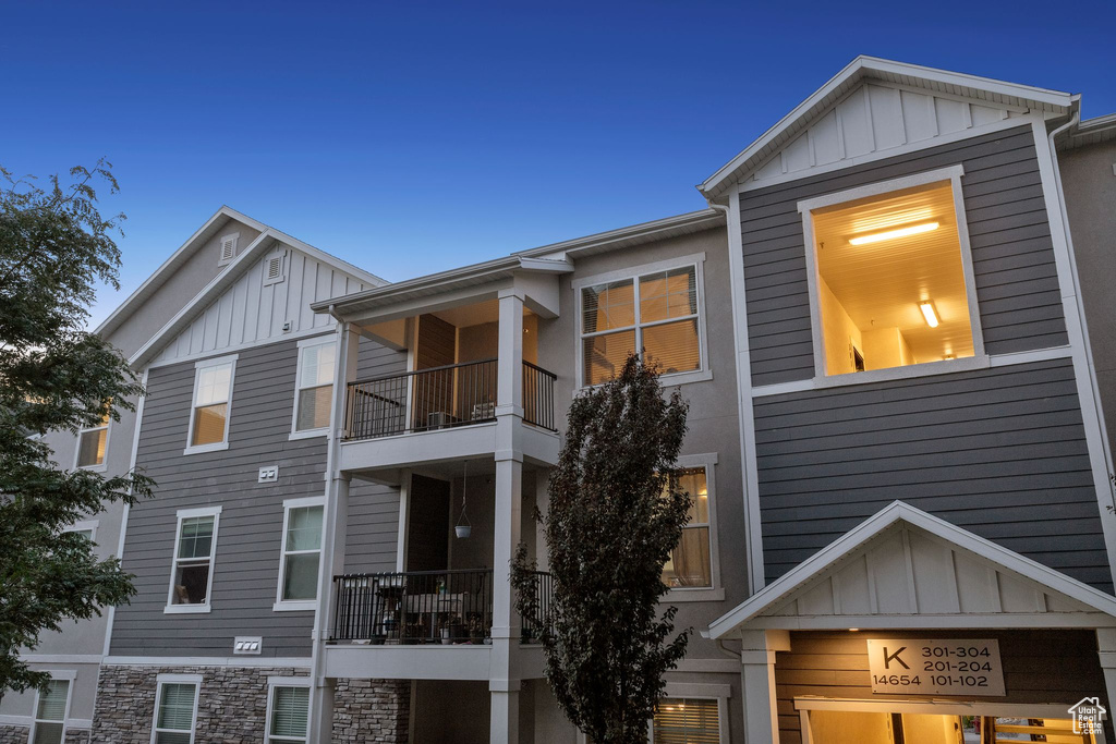 View of side of home featuring board and batten siding and a balcony