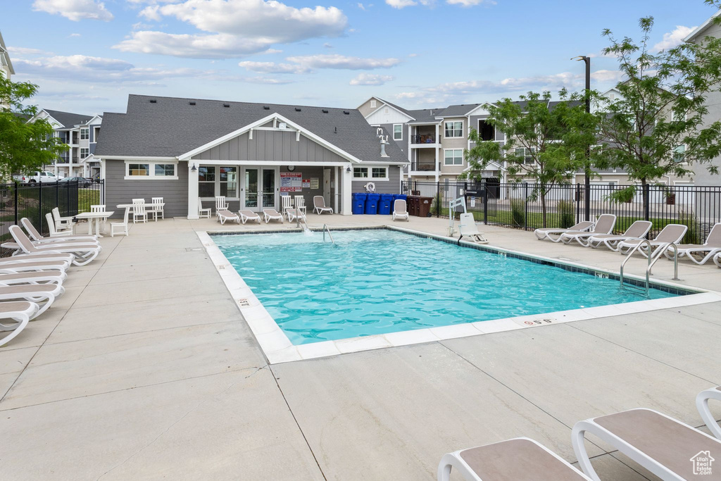 Community pool with a patio area and a residential view