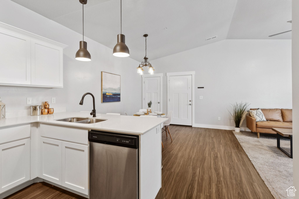 Kitchen with stainless steel dishwasher, vaulted ceiling, a peninsula, white cabinets, and light countertops