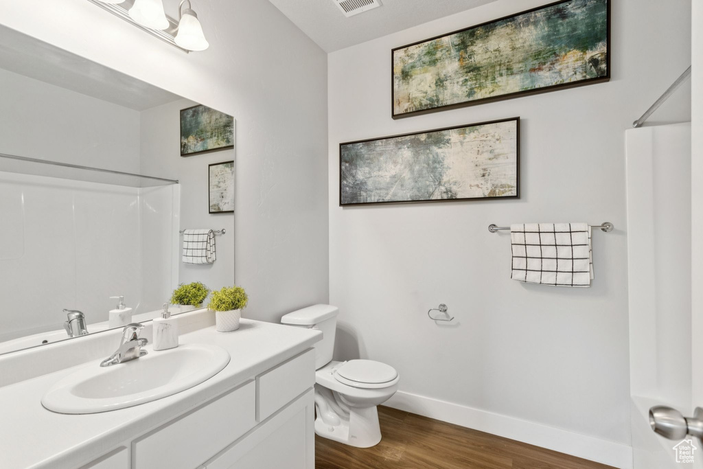 Bathroom with a shower, wood finished floors, and vanity