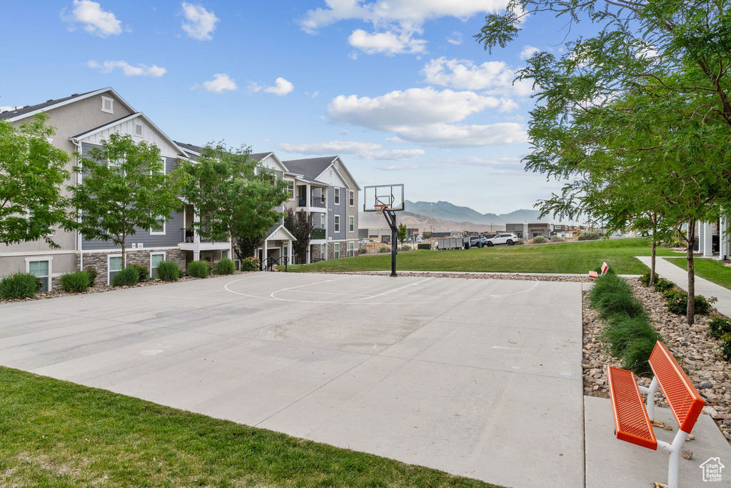 View of sport court with community basketball court, a lawn, a mountain view, and a residential view