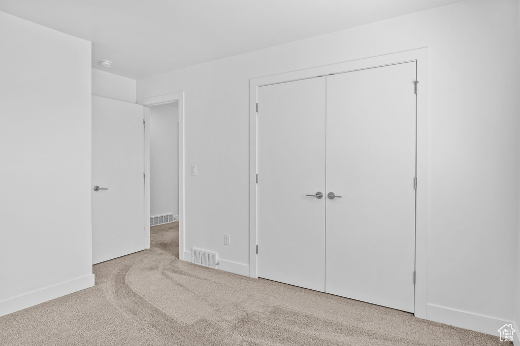 Unfurnished bedroom featuring carpet flooring and a closet