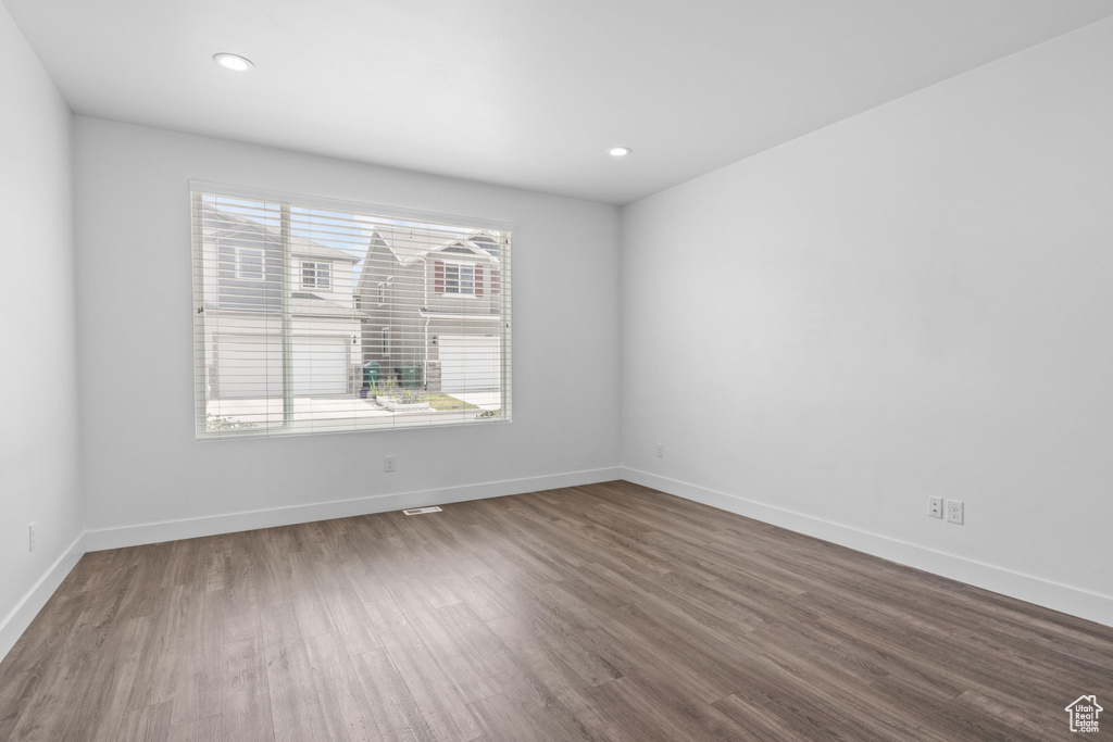 Empty room with dark wood-style floors and recessed lighting