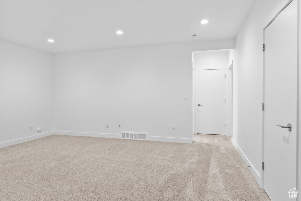 Empty room with recessed lighting and light colored carpet