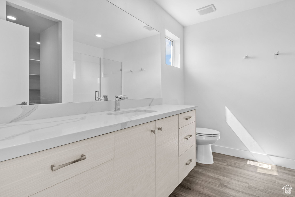 Full bathroom featuring vanity, wood finished floors, and recessed lighting