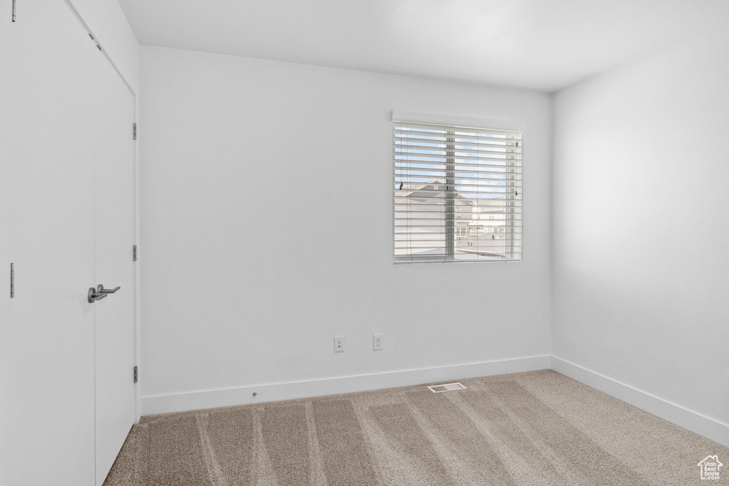 Carpeted empty room with baseboards