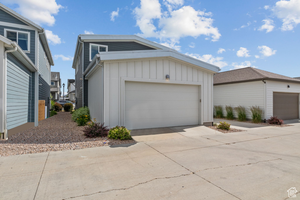 View of front facade with board and batten siding, a garage, and driveway