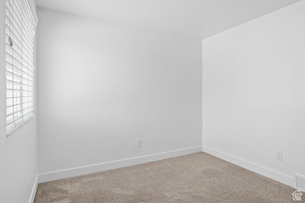 Carpeted spare room with baseboards